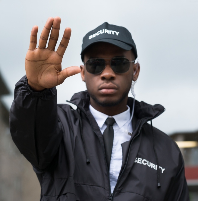 confident young african male security guard making stop gesture